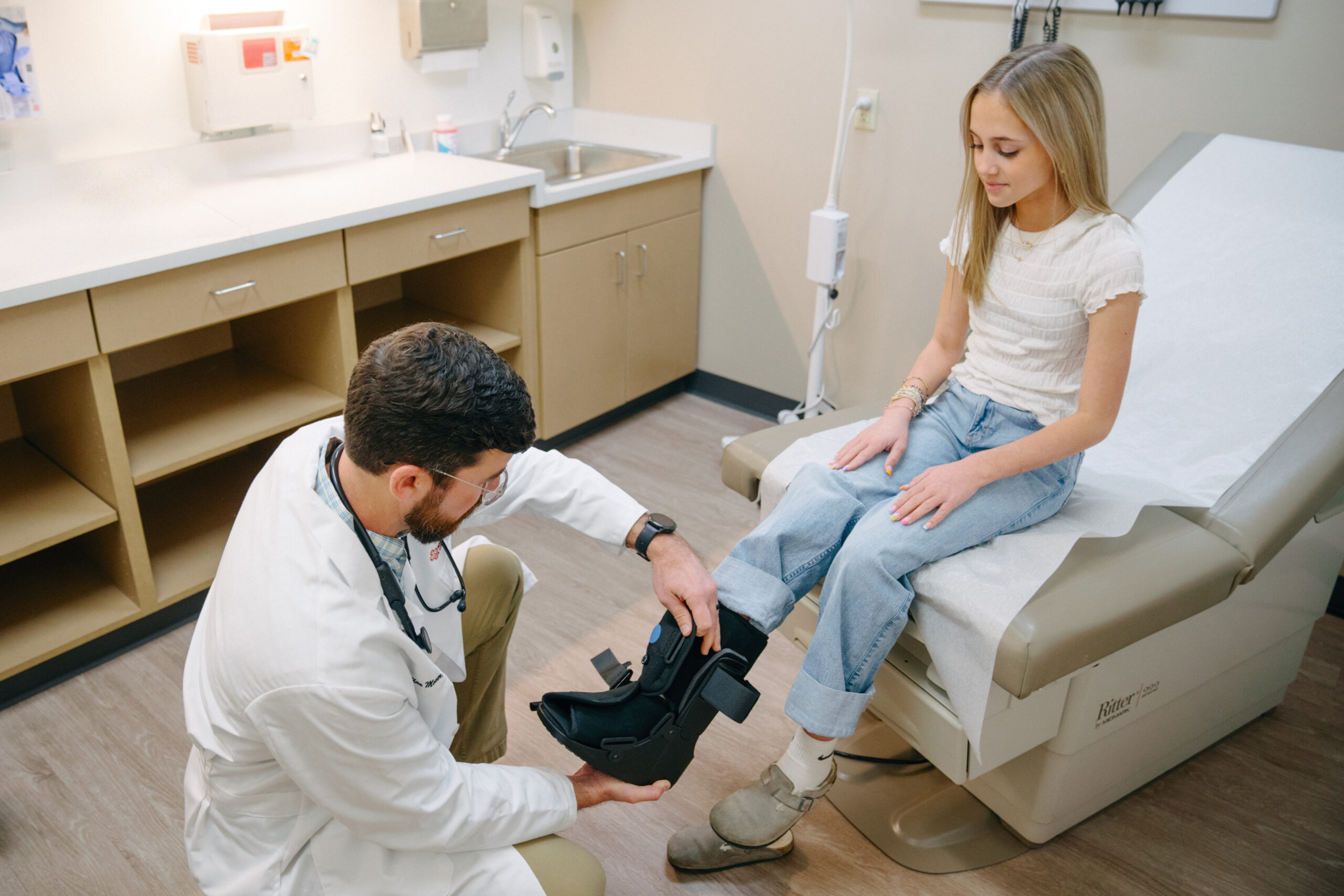 AFC healthcare provider fitting a boot on a young patient after a foot or ankle injury.